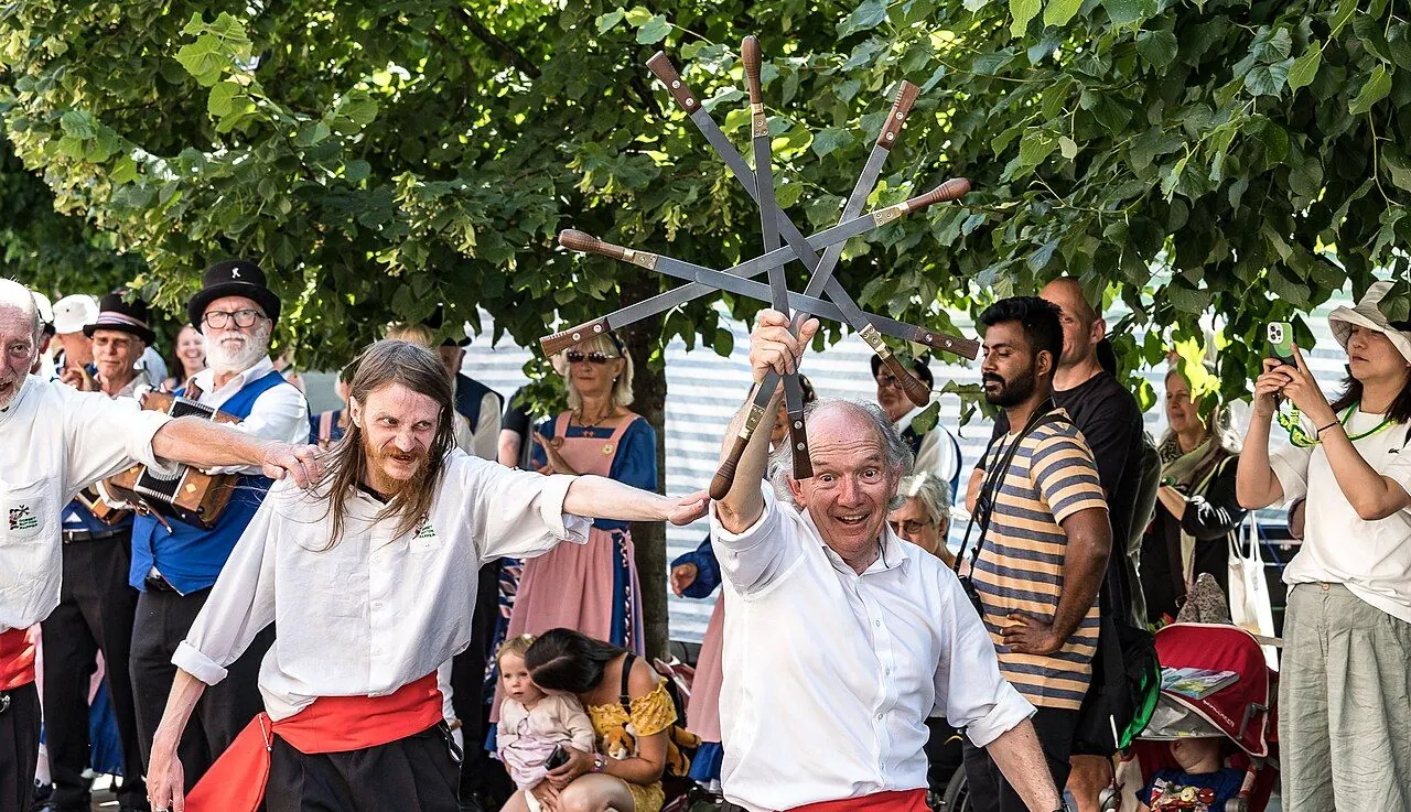 Rapper sword dancers holding up an interlocked sword lock